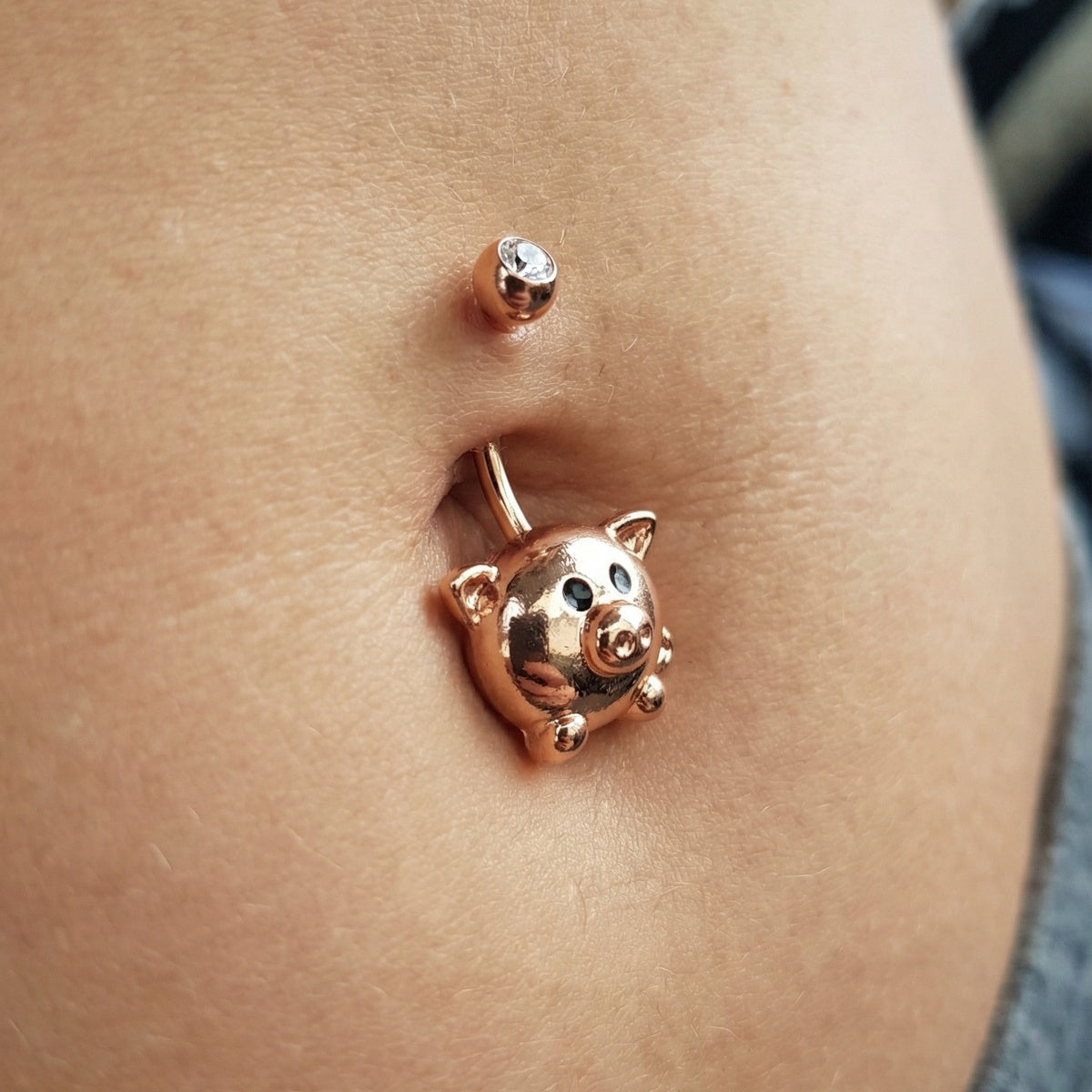 Pig Belly Button Ring 14G 316L Surgical Steel Rose Gold in the belly button piercing of a female model.