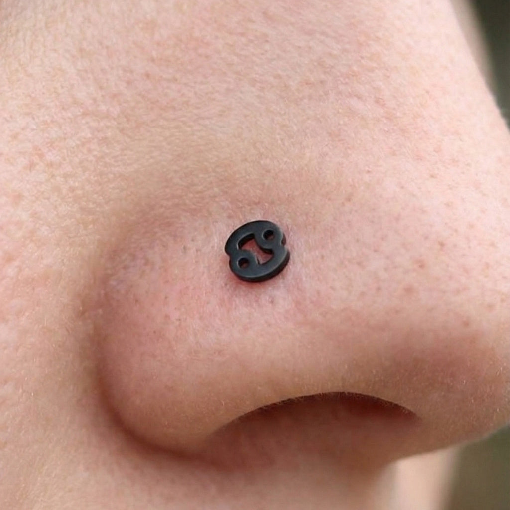 Cancer black surgical steel zodiac nose stud on model.
