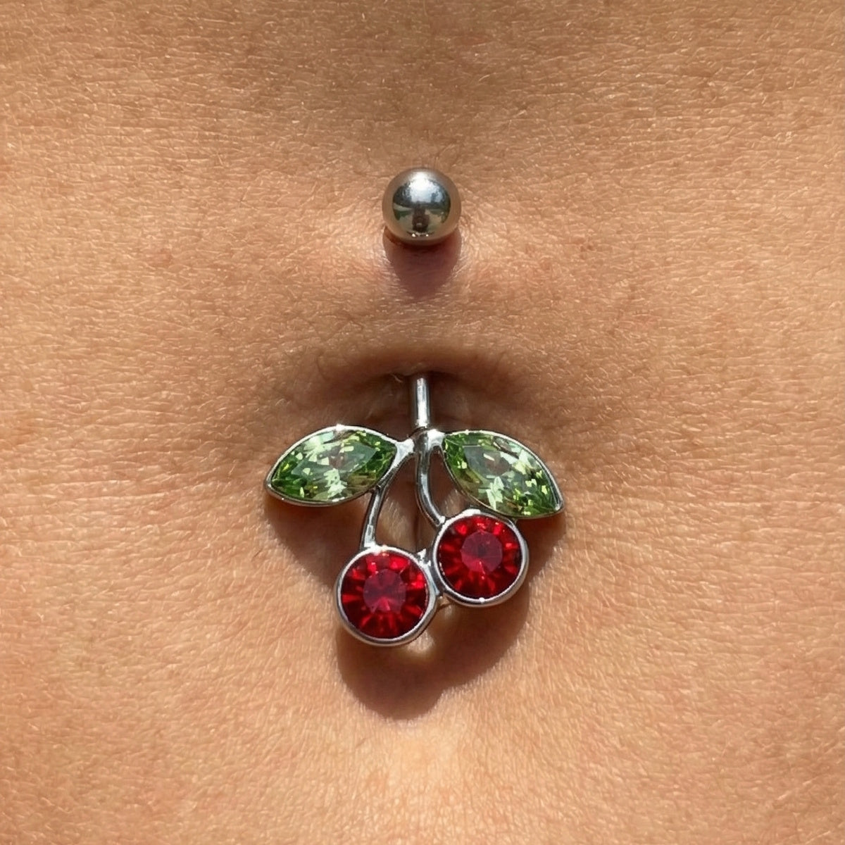Cherry Red Green CZ Belly Ring 14G 316L Surgical Steel in the belly piercing of a model.