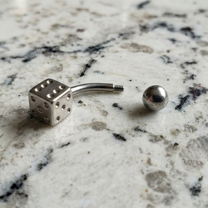 Dice Lucky Gambling Belly Ring 14G 316L Surgical Steel on Countertop.